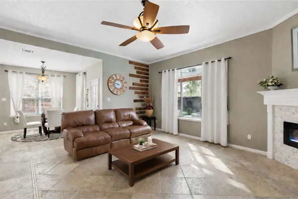 a living room with furniture a fireplace and a large window
