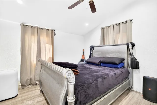 a bedroom with a bed and wooden floor