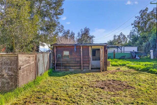a view of a house with a small yard and a large tree