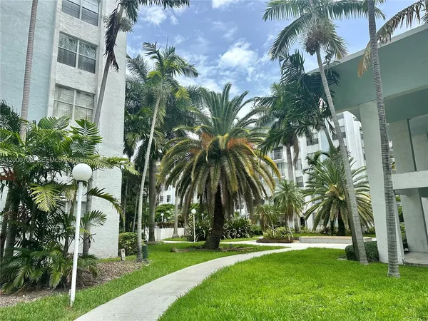 a couple of palm trees sitting in front of a house