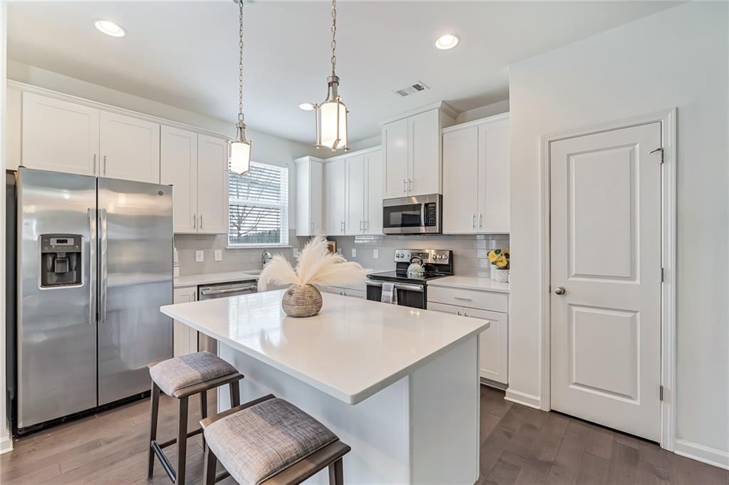 a kitchen with white cabinets and stainless steel appliances