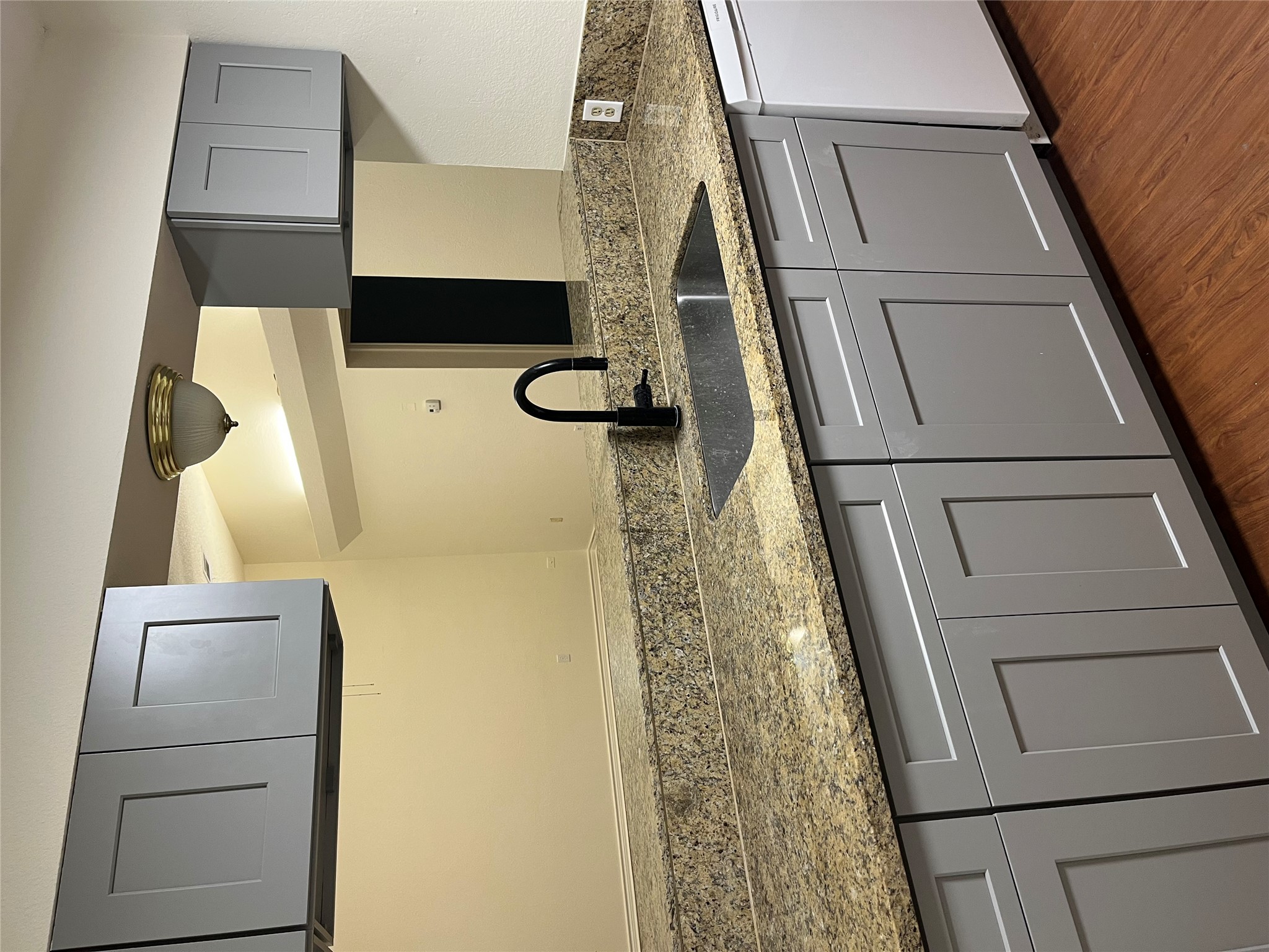 23393 Nameless Road, Unit 144 Leander, TX 78641 - Photo 6 of 23 Kitchen with dark wood finished floors, light stone countertops, a sink, and dishwasher
