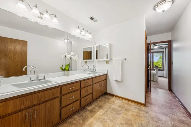 a spacious bathroom with a double vanity sink mirror and shower
