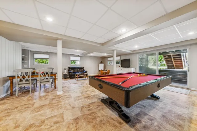 a living room with furniture pool table and window