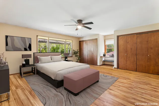 a spacious bedroom with a large bed a chandelier and windows
