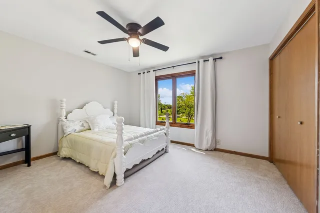 a bedroom with a bed and a large window