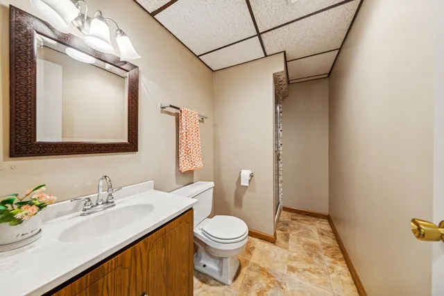 a bathroom with a sink vanity granite and toilet