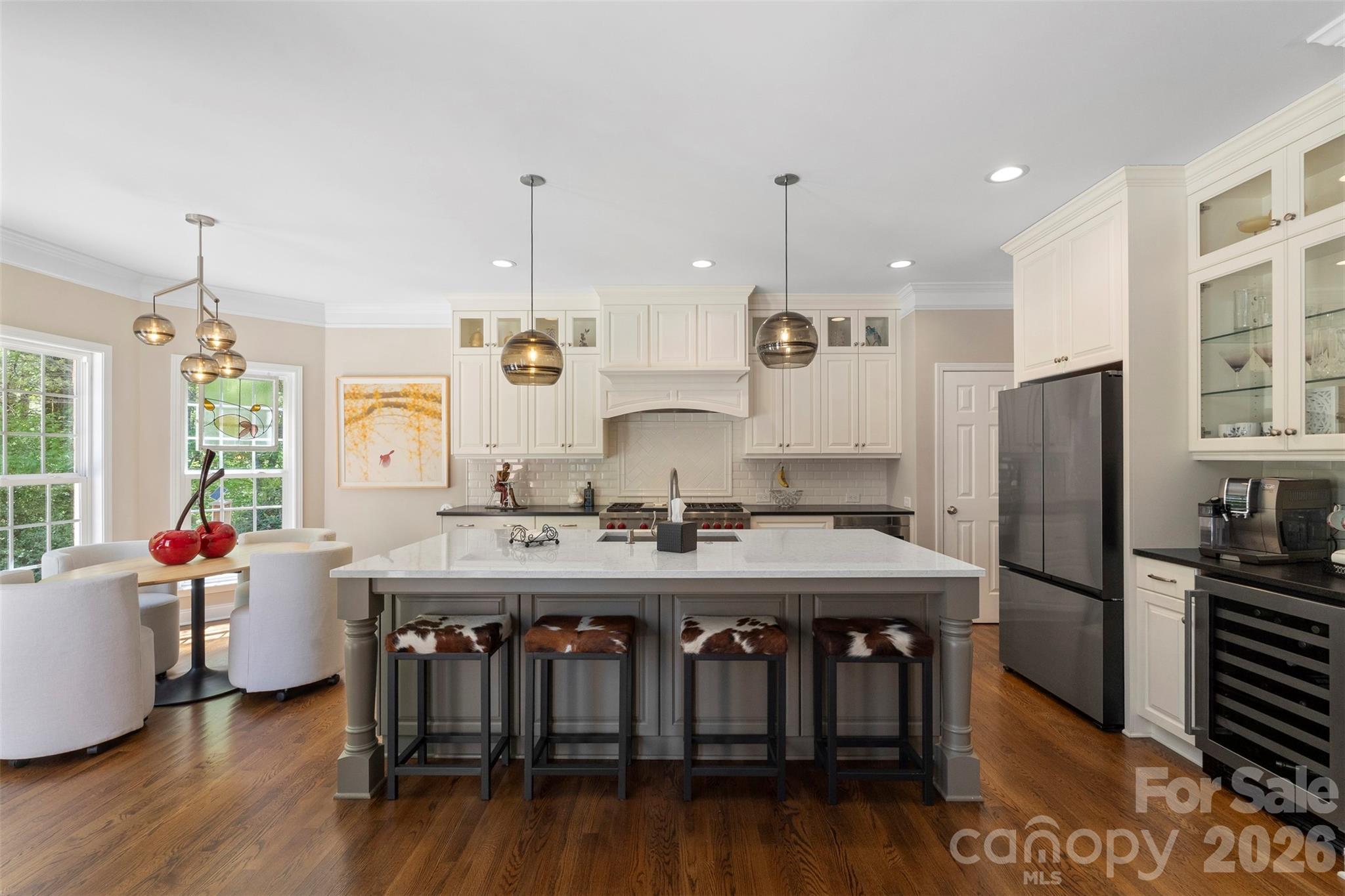 2003 Bauer Place Waxhaw, NC 28173 - Photo 16 of 47 a kitchen with stainless steel appliances granite countertop a stove a refrigerator a kitchen island a dining table and chairs with wooden floor