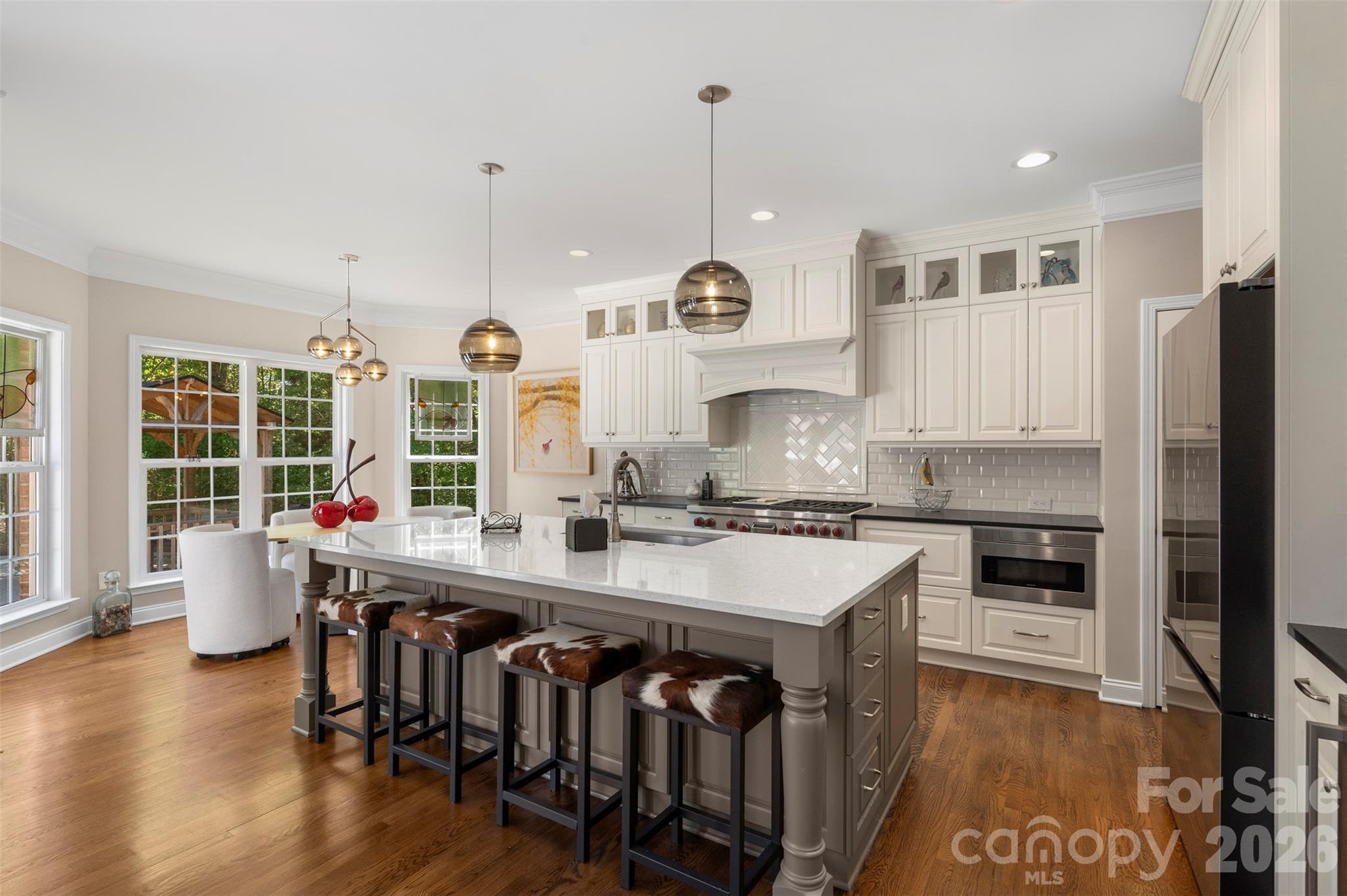 2003 Bauer Place Waxhaw, NC 28173 - Photo 3 of 47 a large kitchen with kitchen island a stove a sink a refrigerator and wooden floor
