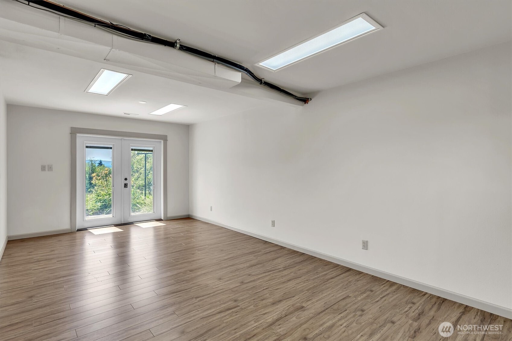 231 Robertson Road Longview, WA 98632 - Photo 17 of 37 a view of an empty room with wooden floor and a window