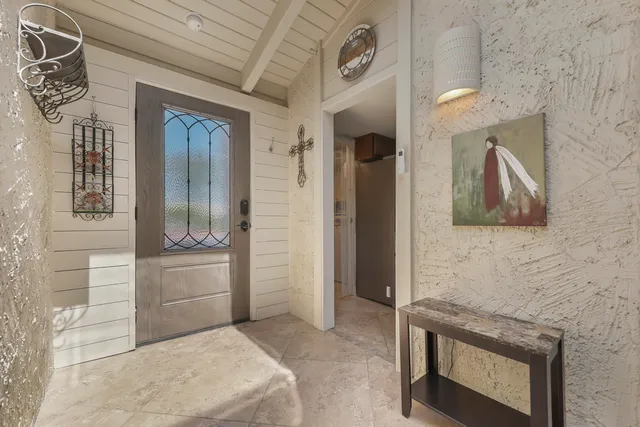 a living room with furniture kitchen view and a chandelier