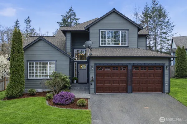 a front view of a house with a yard and garage