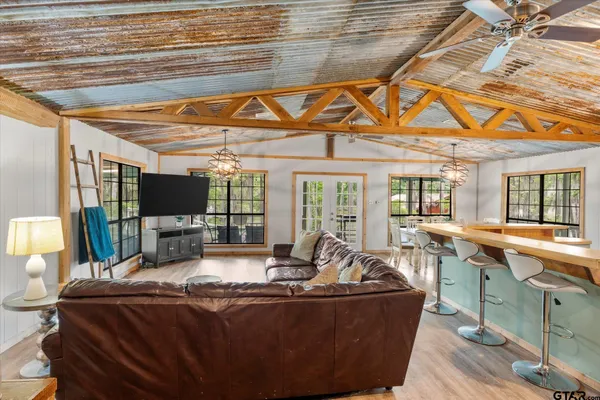 a dining room with furniture a chandelier and wooden floor