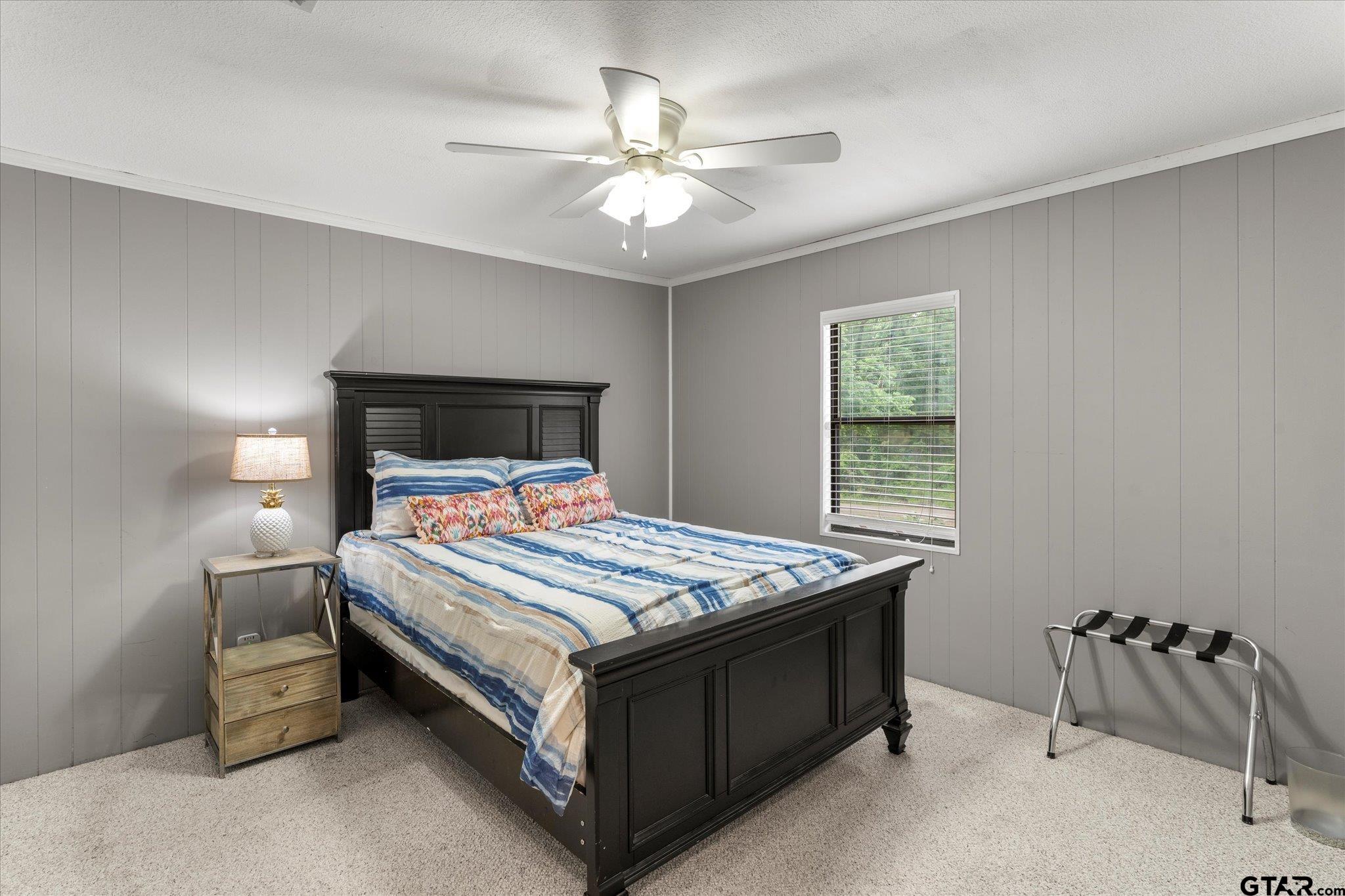 230 Sesame Street West Karnack, TX 75661 - Photo 40 of 44 a bedroom with a bed and a chandelier