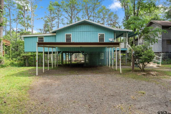 a backyard of a house with wooden fence and trees