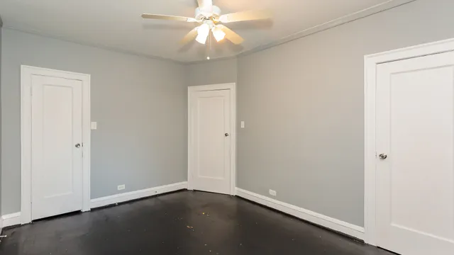 an empty room with a ceiling fan and a window
