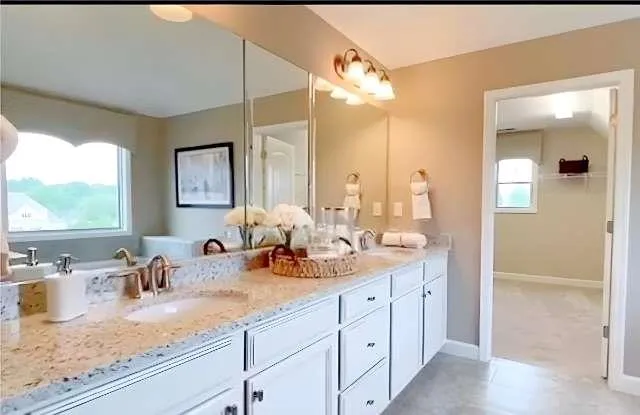 a bathroom with double sink and a mirror