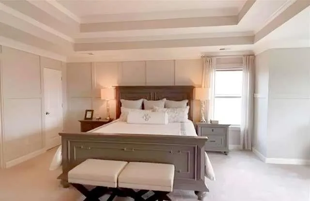 a bedroom with a bed a mirror and a window