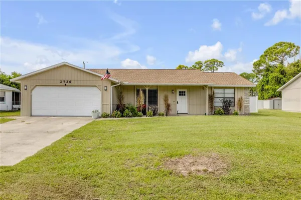 a front view of a house with a garden and yard