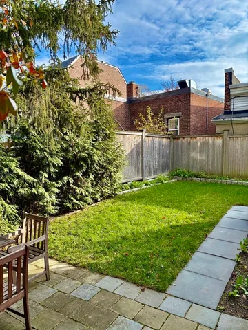 a view of backyard with barbeque grill and wooden fence