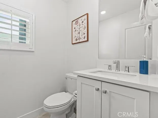 a bathroom with a granite countertop toilet sink and mirror