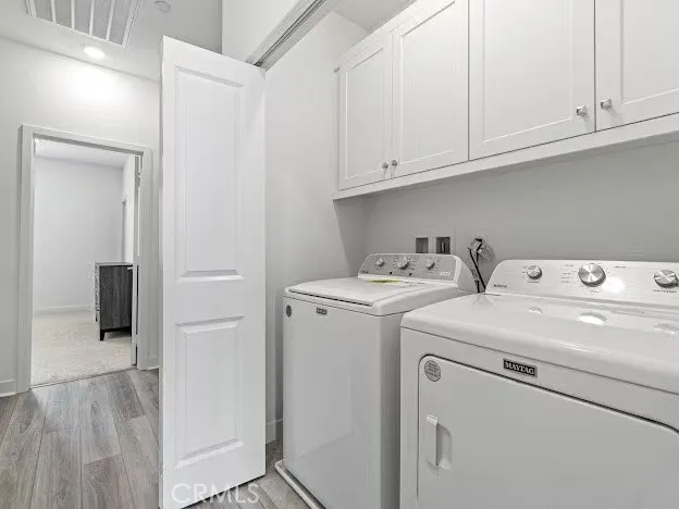 a large white kitchen with wooden floor and a sink