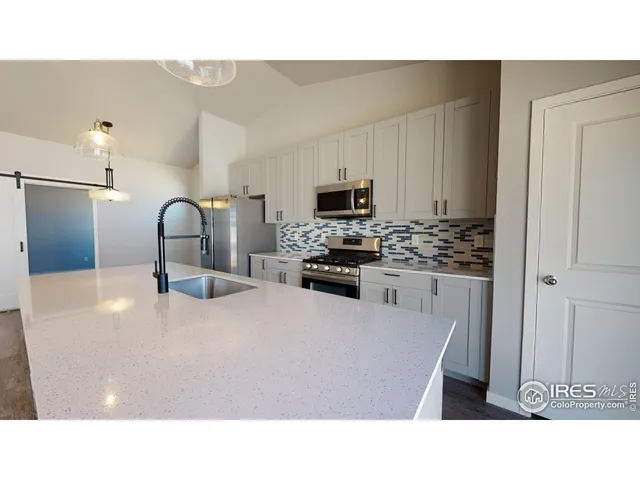 a kitchen with kitchen island a sink stainless steel appliances and cabinets