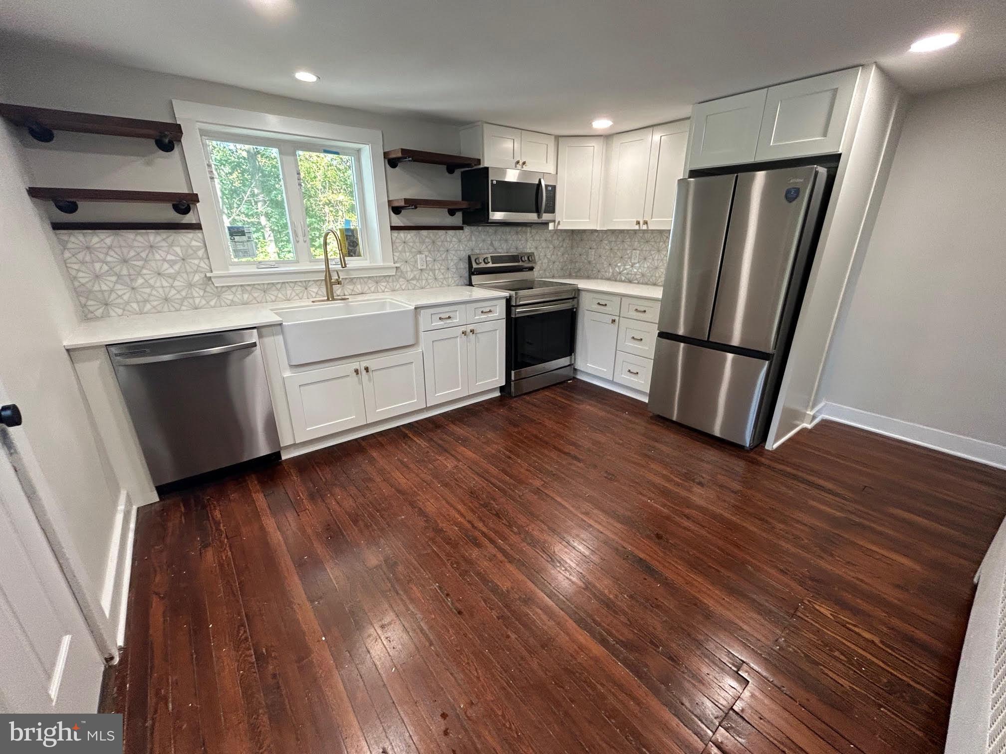 1355 Penn Grant Road, Unit 1 Strasburg, PA 17579 - Photo 2 of 14 a kitchen with wooden floors a sink stainless steel appliances and cabinets
