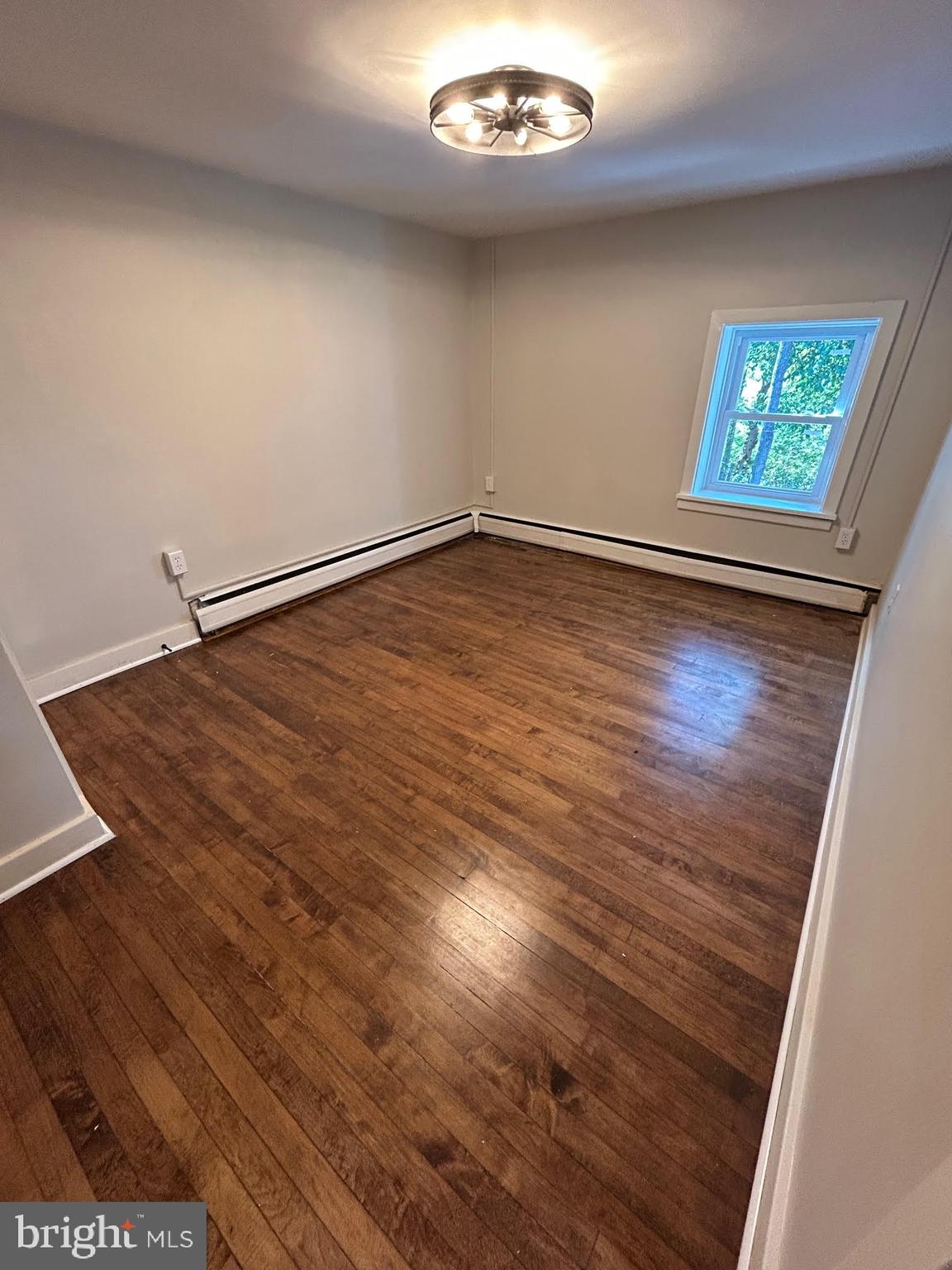 1355 Penn Grant Road, Unit 1 Strasburg, PA 17579 - Photo 6 of 14 an empty room with wooden floor and windows