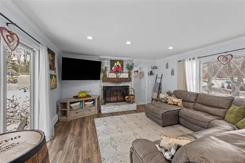 a living room with furniture a flat screen tv and a floor to ceiling window