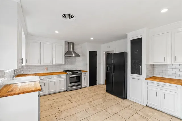 a kitchen with granite countertop a refrigerator stove top oven and sink