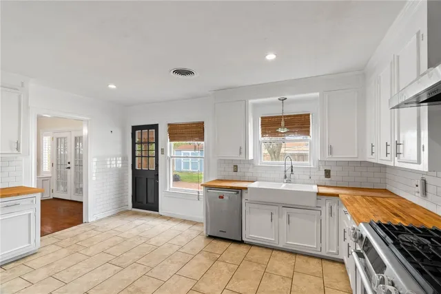 a large kitchen with a stove a sink dishwasher and a refrigerator