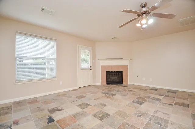 a view of an empty room with window and fireplace