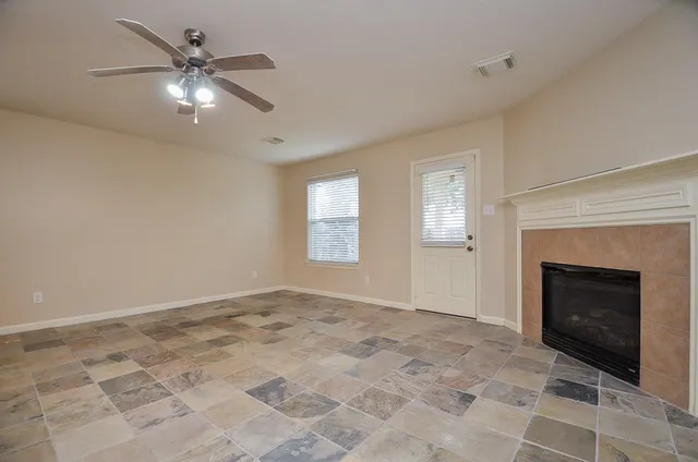 a view of an empty room with window and fireplace