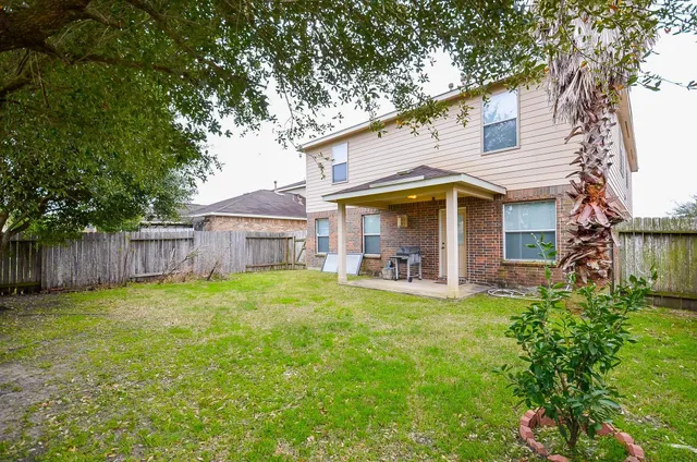 a view of a house with a yard and sitting area