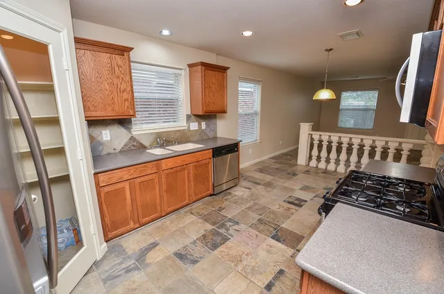 a kitchen with stainless steel appliances granite countertop a sink stove and cabinets