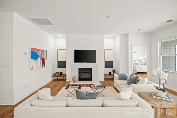 a living room with furniture a flat screen tv and a fireplace