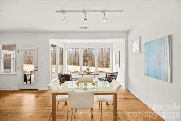 a kitchen with a dining table chairs refrigerator and cabinets