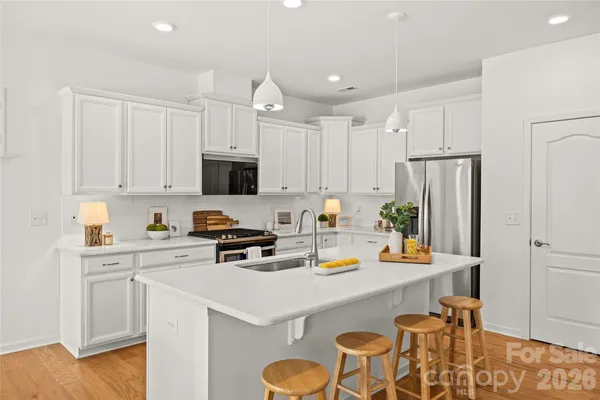 a living room with stainless steel appliances kitchen island granite countertop a sink and cabinets