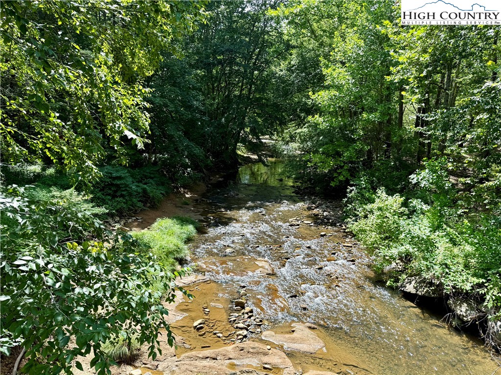 Lot 201 Twin Rivers Drive Boone, NC 28607 - Photo 13 of 14 a backyard of a house with lots of green space and chair