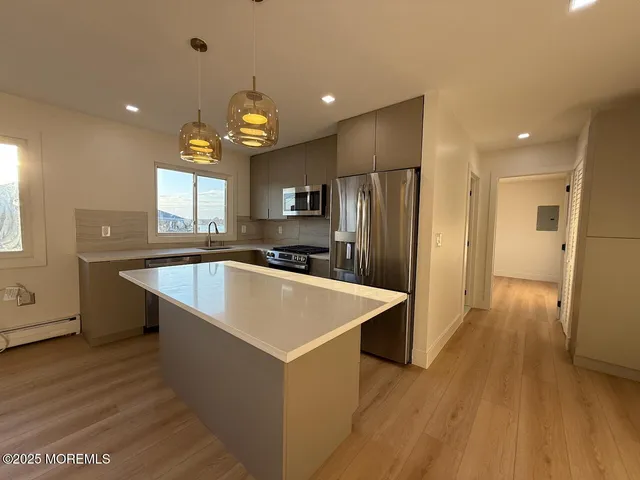 a large kitchen with stainless steel appliances a refrigerator and a sink