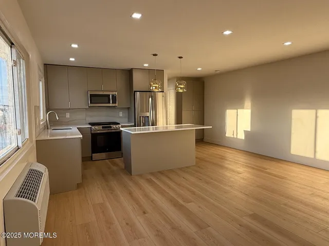 a large kitchen with stainless steel appliances granite countertop a stove a sink and a refrigerator