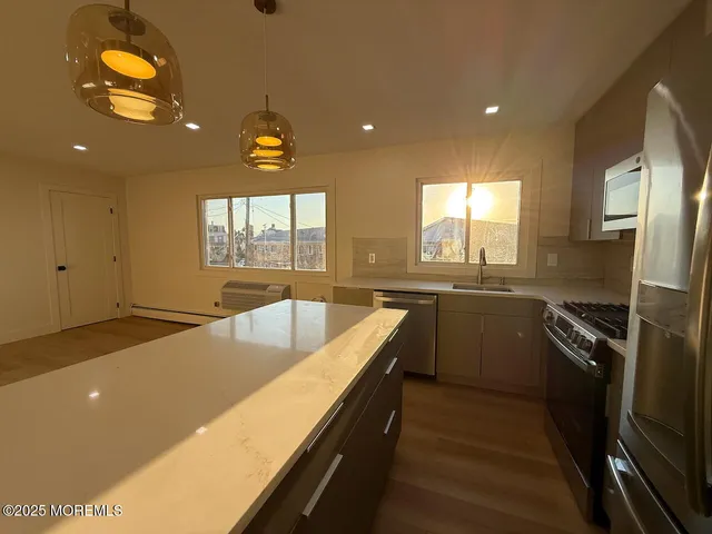 a kitchen with stainless steel appliances granite countertop sink stove and refrigerator