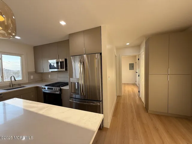a kitchen with granite countertop a refrigerator and a sink