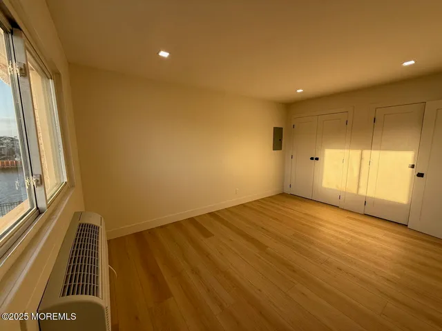 a view of an empty room with wooden floor