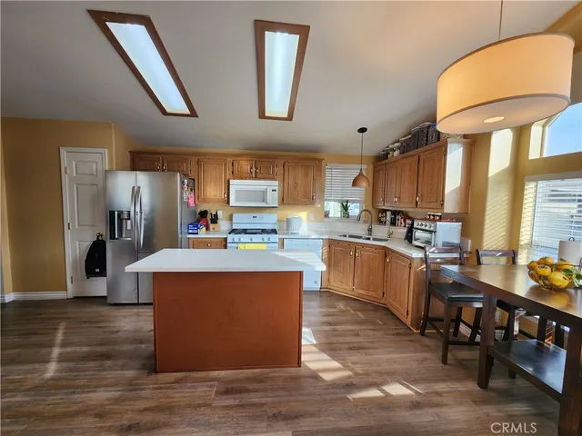 a kitchen with stainless steel appliances kitchen island granite countertop a stove refrigerator and cabinets