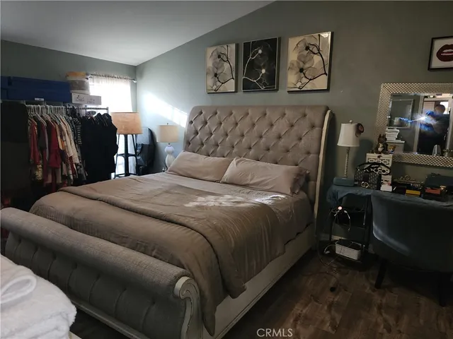 a bedroom with a bed and painting on the wall