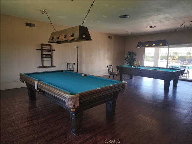 a room with wooden floors and pool table