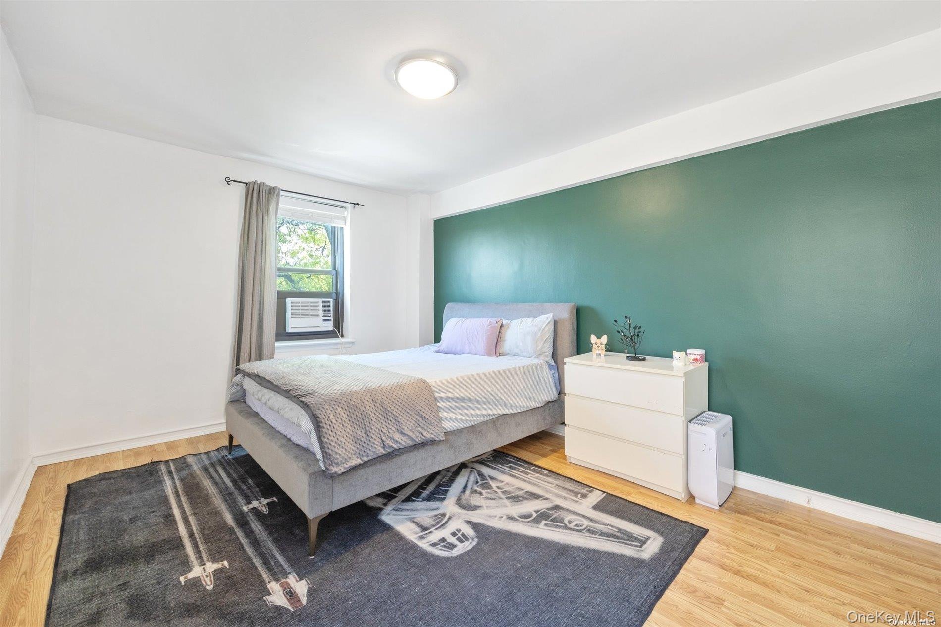 75-20 Bell Boulevard, Unit 5A Queens, NY 11364 - Photo 4 of 7 a bedroom with a bed and a window