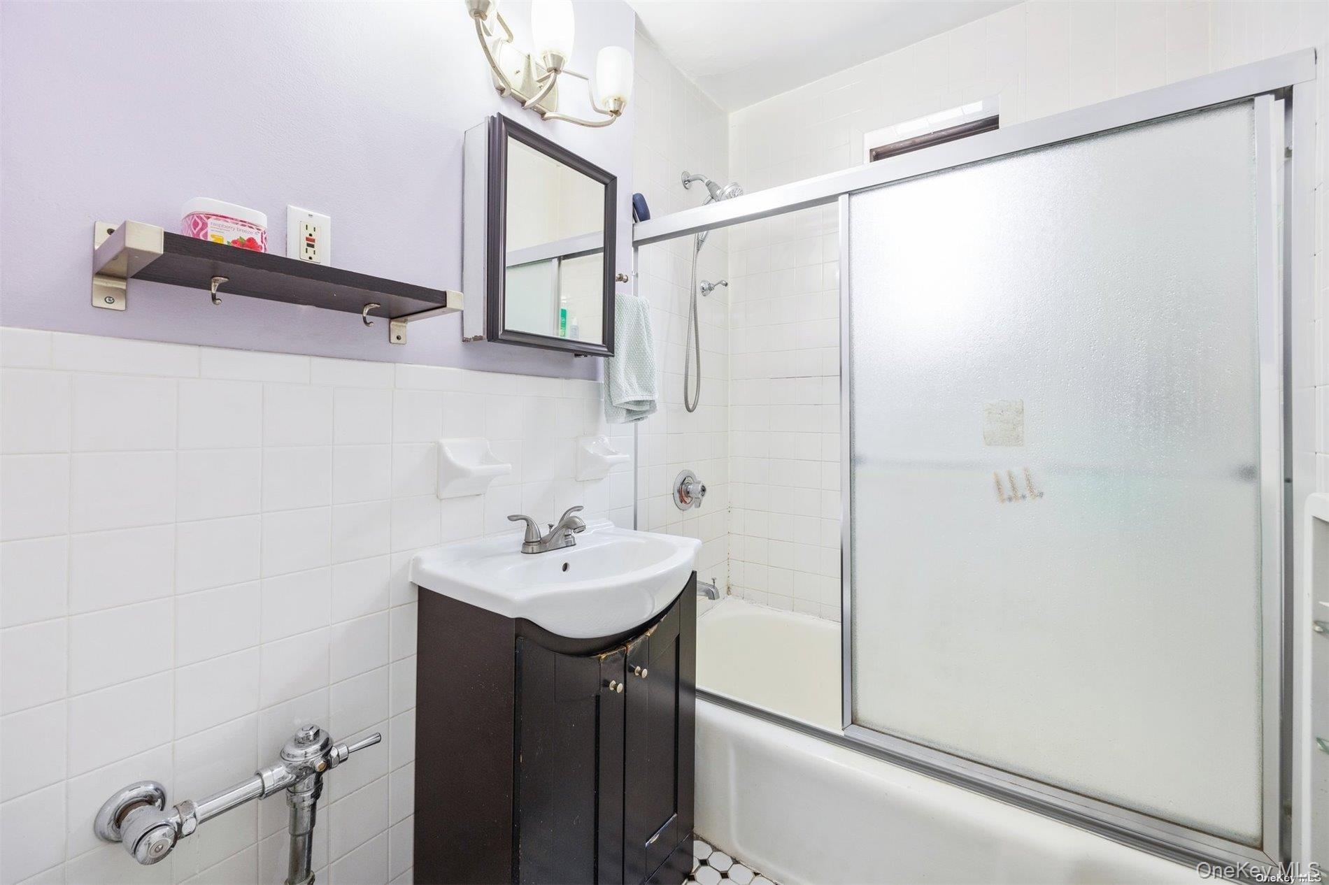 75-20 Bell Boulevard, Unit 5A Queens, NY 11364 - Photo 5 of 7 a bathroom with a sink and mirror